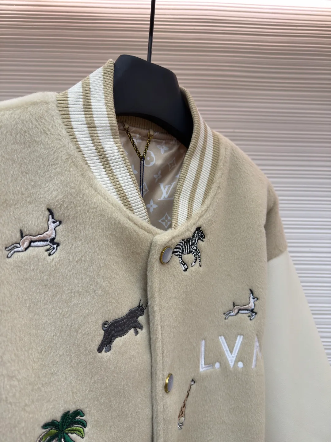 LOUIS VUITTON animal embroidered baseball uniform ●Original version: 48000 purchased and developed ●Item number: 1682284-B90 ●Fabric: cotton fabric ●Technology: embroidery production ●Color: apricot ●Version: fitted version ●Weight: about 1070 grams ●Size: 46-48-50-52 ●Description: The main body of this Louis Vuitton embroidered baseball jacket is made of high-quality wool blended fabric, which is crisp and soft. The sleeves are made of eco-friendly artificial leather with a matte texture, which contrasts with the body in terms of material and touch. The animal, palm tree and other patterns on the body of the clothing are all completed by hand-stitched embroidery technology, using multi-color embroidery threads to embroider in layers. The patterns are three-dimensional and vivid, and the stitching in the details is fine and even. The letter logo uses flat embroidery technology, and the font outline is clear and regular. The ribbed collar, cuffs and hem of the jacket are made of high-elastic knitted fabric, which will not loosen easily after being worn for a long time. The metal snaps on the placket are custom-made hardware with a thick texture and anti-oxidation. The overall tailoring is a loose oversize version, and the splicing uses hemming stitching technology, and the lines are smooth and smooth. Every craft detail is in line with the brand's luxury product production standards, creating a ready-to-wear garment that has both a sense of design and practical wearability. The overall wiring is straight and delicate, the fabric is comfortable and soft, and the color is consistent without color difference. It can be matched with the same style to create a fashionable look and control various occasions. Customized accessories, complete with three standards, same style for men and women!